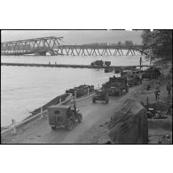 Un convoi de véhicules emprunte le pont flottant de classe 10 monté sur le Rhin à Spire par le 101e régiment du génie (101e RG) de la 1re armée française.