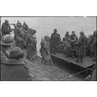Des sapeurs du génie de la 1re armée française embarquent sur des barges d'assaut M2 assemblées en portière pour traverser le Rhin.