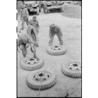Changement de chambres à air sur des pneus de véhicules par des soldats du 3e escadron du 11e groupe d'escadrons de réparation divisionnaire (11e GERD).
