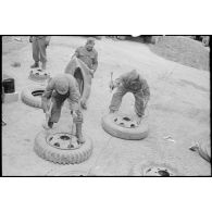 Changement de chambres à air sur des pneus de véhicules par des soldats du 3e escadron du 11e groupe d'escadrons de réparation divisionnaire (11e GERD).