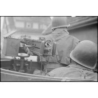 Membres d'équipage d'un scout-car ou d'un half-track. Au premier plan, le servant d'une mitrailleuse 12,7 mm.