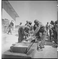 Nettoyage des gamelles à l'issue d'un repas pour des soldats dans le camp d'entraînement disciplinaire américain des Milles.