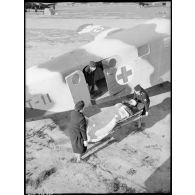 Transport d'un blessé à bord d'un avion sanitaire avec l'aide des infirmières de l'air.