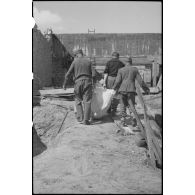 Des prisonniers allemands exhument d'une des fosses certains des corps de 69 résistants fusillés par les Allemands avant l'été 1944 à la citadelle de Port-Louis.