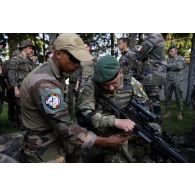 Un soldat du 35e régiment d'infanterie (RI) présente une mitrailleuse FN Minimi à son homologue roumain à Lunca de Sus, en Roumanie.