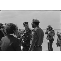 Discussion entre le colonel Salvan et général Erskine entourés de journalistes.