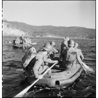 Des membres du groupe de commandos d'Afrique, devenu 5e bataillon de choc, à bord de rubber boats longent les falaises du Cap Nègre (reconstitution).
