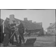 Caméramans du service cinématographique de la Marine (SCA/Marine) en tournage avec une caméra Debrie dans une cour de ferme.