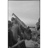 Chargement par des canonniers d'un canon de 75 mm antiaérien camouflé, baptisé Longewalde, affecté à une batterie d'artillerie de défense côtière de la Marine nationale sur le littoral.