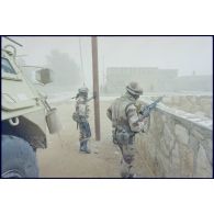 Dans une rue d'Al Salman, un tireur d'élite du 3e RIMa (régiment d'infanterie de marine), son fusil de précision FR-F2 en main, se tient debout derrière un muret.