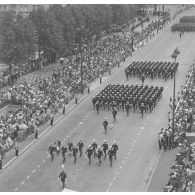 Vue aérienne du défilé à pied. Passage des drapeaux et leur garde de l'école spéciale militaire (ESM) de Saint-Cyr et de l'école militaire interarmées (EMIA), lors de la cérémonie du 14 juillet 1977.
