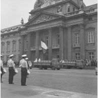 Défilé motorisé devant l'Ecole militaire. Passage de camions transportant des sapeurs de la brigade de sapeurs-pompiers de Paris (BSPP) en tenue de protection incendie et tractant un ventilateur, lors de la cérémonie du 14 juillet 1977.
