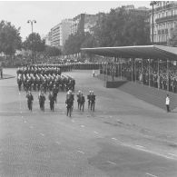 Défilé à pied des drapeaux et leur garde de l'école spéciale militaire (ESM) et de l'école militaire interarmées (EMIA) de Saint-Cyr-Coëtquidan, et passage devant la tribune présidentielle lors de la cérémonie militaire du 14 juillet 1974 sur la place de la Bastille.