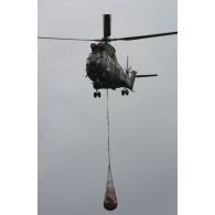 Hélicoptère Puma SA-330 hélitreuillant un bac souple lors des présentations de matériel de l'armée à Mourmelon.