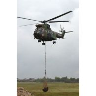 Hélicoptère Puma SA-330 hélitreuillant un bac souple lors des présentations de matériel de l'armée à Mourmelon.