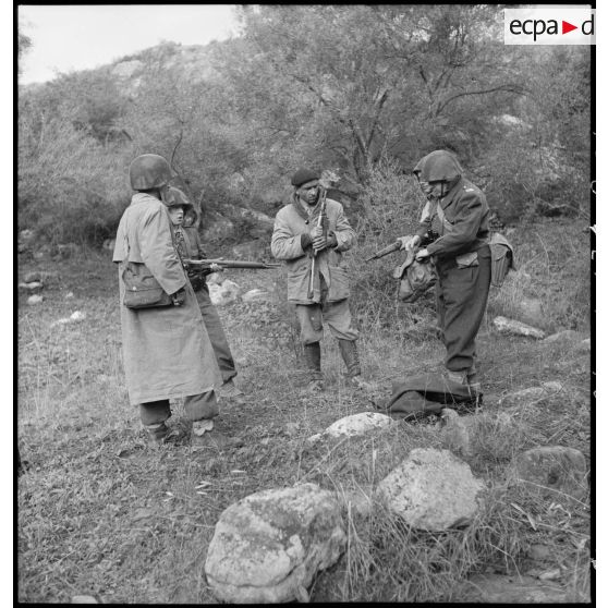 Fouille d'un prisonnier armé d'un pistolet mitrailleur Sten par un capitaine du 9e RZ (régiment de zouaves) lors d'une opération en Kabylie.