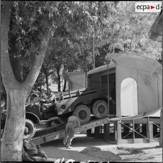 Embarquement d'une jeep sur caisson simulateur d' avion de transport expediter C45 à Sétif.