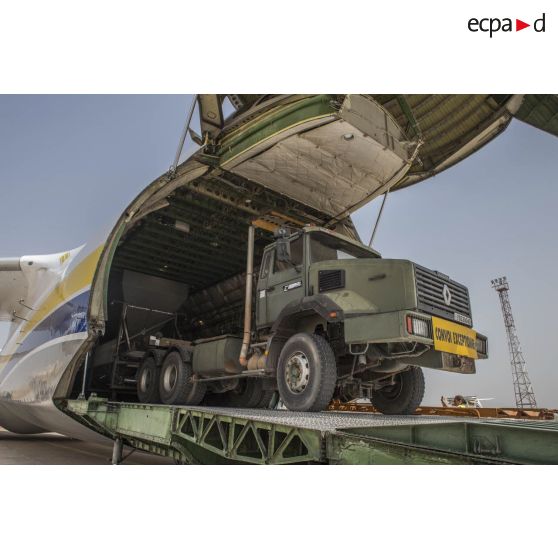 Déchargement d'une centrale d'enrobage à bitume tractée par un camion Renault CBH-380, depuis la soute d'un Antonov An 124-100 stationnant sur le tarmac de la Base aérienne 172 Fort-Lamy à N'Djamena.