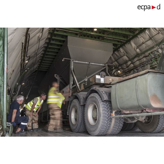 Déchargement d'une centrale d'enrobage à bitume tractée par un camion Renault CBH-380, depuis la soute d'un Antonov An 124-100 stationnant sur le tarmac de la Base aérienne 172 Fort-Lamy à N'Djamena.