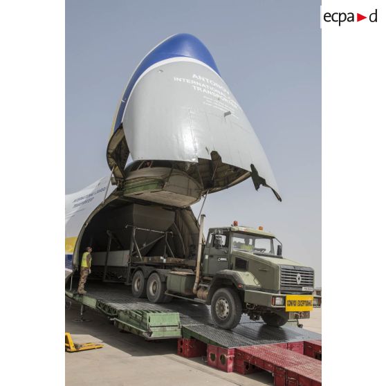 Déchargement d'une centrale d'enrobage à bitume tractée par un camion Renault CBH-380, depuis la soute d'un Antonov An 124-100 stationnant sur le tarmac de la Base aérienne 172 Fort-Lamy à N'Djamena.