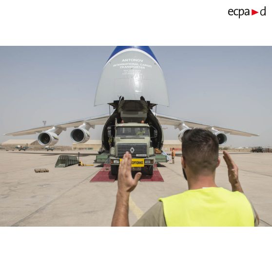 Déchargement d'une centrale d'enrobage à bitume tractée par un camion Renault CBH-380, depuis la soute d'un Antonov An 124-100 stationnant sur le tarmac de la Base aérienne 172 Fort-Lamy à N'Djamena.