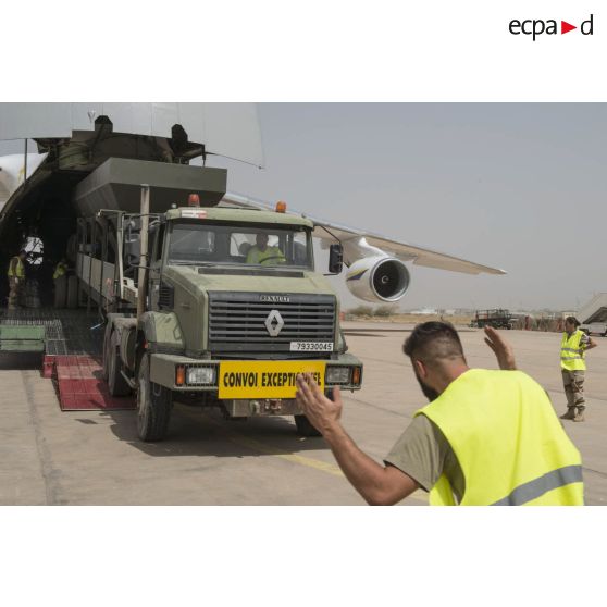 Déchargement d'une centrale d'enrobage à bitume tractée par un camion Renault CBH-380, depuis la soute d'un Antonov An 124-100 stationnant sur le tarmac de la Base aérienne 172 Fort-Lamy à N'Djamena.