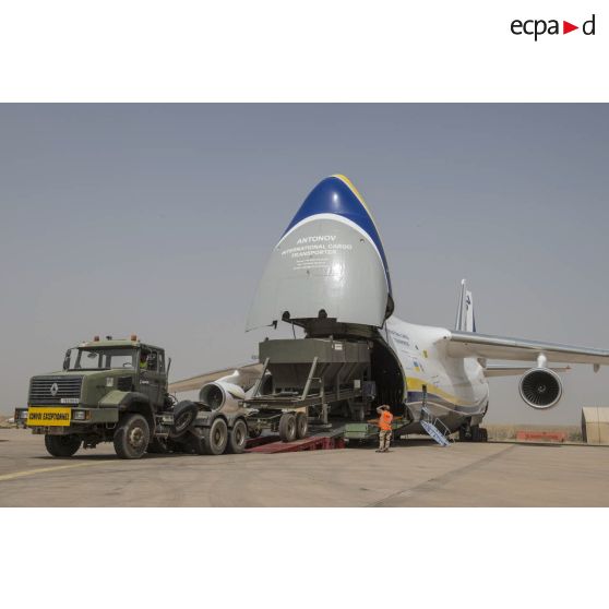 Déchargement d'une centrale d'enrobage à bitume tractée par un camion Renault CBH-380, depuis la soute d'un Antonov An 124-100 stationnant sur le tarmac de la Base aérienne 172 Fort-Lamy à N'Djamena.