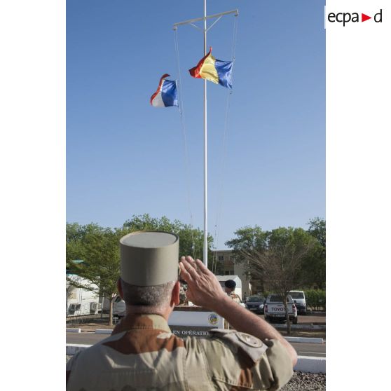 Le  general de division Patrick Bréthous, commandant la force Barkhane, salue les couleurs lors d'une cérémonie de lever des couleurs sur la base aérienne 172 Fort-Lamy à N'Djamena.