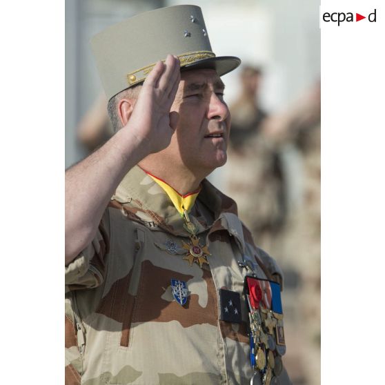 Le  general de division Patrick Bréthous, commandant la force Barkhane, salue les couleurs lors d'une cérémonie de lever des couleurs sur la base aérienne 172 Fort-Lamy à N'Djamena.