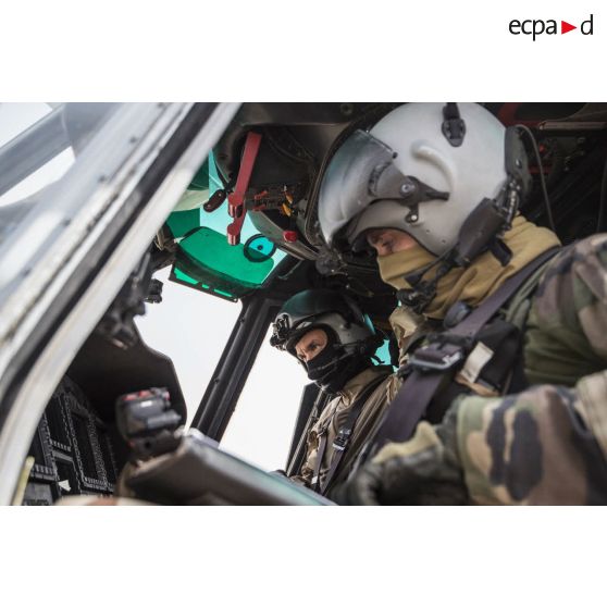 Un pilote et son co-pilote effectuent les vérifications nécessaires au niveau du tableau de bord de leur hélicoptère Caracal EC-725, avant décollage pour une mission depuis la base aérienne 172 Fort-Lamy à N'Djamena.