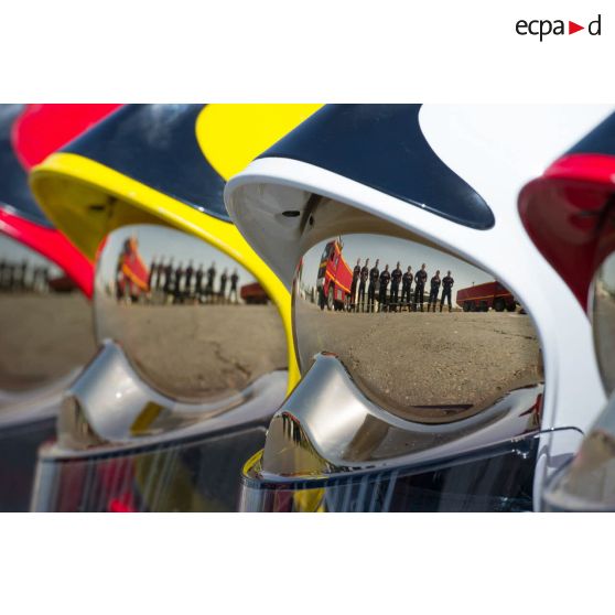 Photographie de groupe en reflet sur la visière de casques du détachement des pompiers de l'Air de la BA 172 (base aérienne) Sergent-chef Adji Kossei située sur l'aéroport de N'Djamena, à l'occasion du 70e anniversaire des pompiers de l'Air.