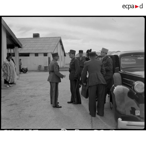 Le général Philippe Leclerc est reçu par une autorité militaire, sur un aérodrome.