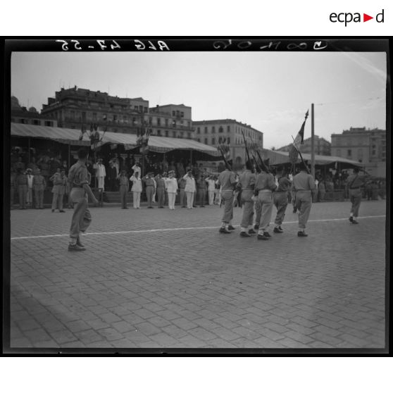 Défilé de la garde au drapeau d'une unité militaire, sous le regard d'autorités militaires.