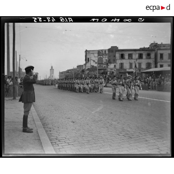 Défilé d'une unité militaire, sous le regard du général Schlesser.