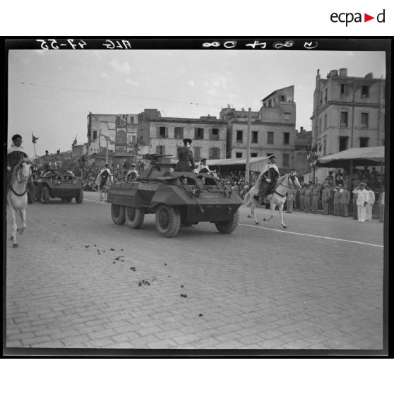 Le général Schlesser défile à bord d'un véhicule blindé, sous le regard d'autorités militaires.