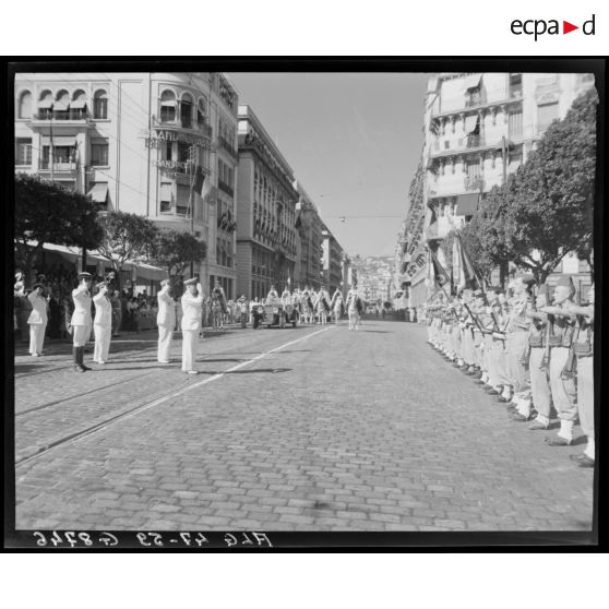 Des autorités militaires, parmi lesquelles le général Schlesser, saluent une unité militaire, à l'occasion d'un défilé, à Alger.