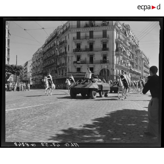 Le général Schlesser défile à bord d'un véhicule blindé, accompagné d'une unité de spahis, à l'occasion d'une cérémonie militaire, à Alger.