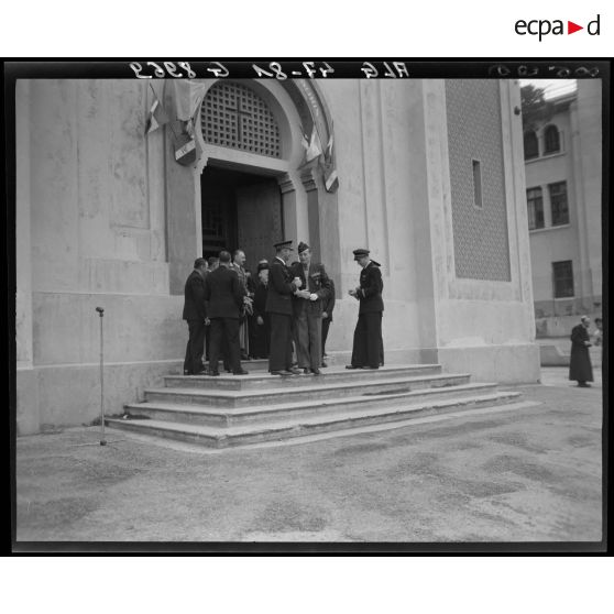 Le général Schlesser s'entretient avec une autorité militaire, devant l'entrée principale d'une église.