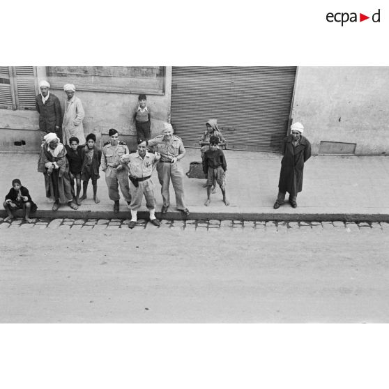 Trois militaires dans une rue de Mouzaïaville, avec la population.