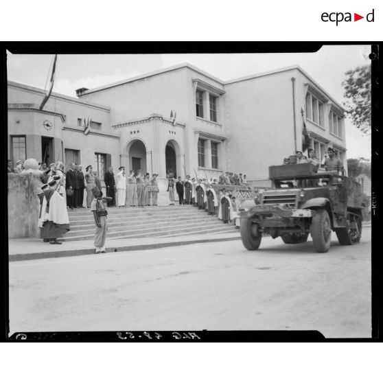 Défilé de half-tracks dans les rues de Mouzaïaville lors d'une cérémonie militaire.