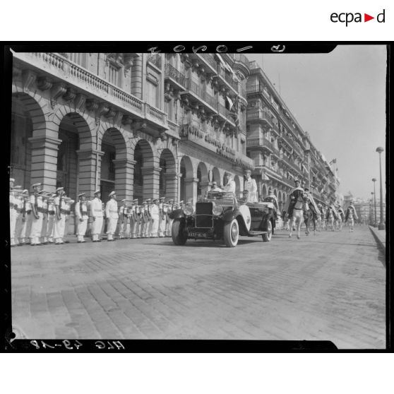 Le gouverneur général de l'Algérie, Marcel Naegelen, passe en revue une unité de la Marine nationale, à bord d'une voiture, escorté par une unité montée de spahis.