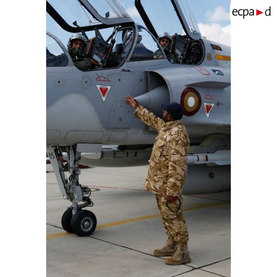 Les pilotes qataris, au cockpit de leur avion de combat Mirage 2000-5 QA 85, prêts au départ en mission, discutent avec un personnel de piste.