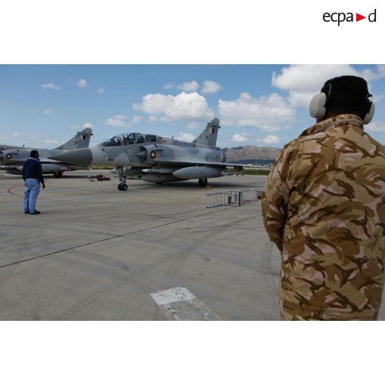 Pilotes qataris au cockpit de leur avion de combat Mirage 2000-5 QA 85 en phase d'allumage, prêts au départ en mission au signal du mécanicien de piste.