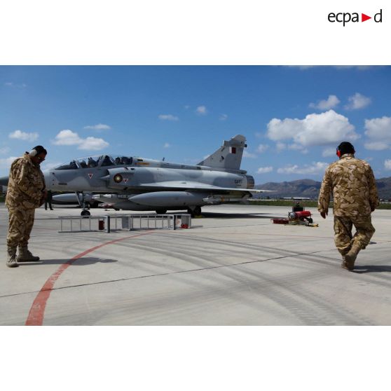 Pilotes qataris au cockpit de leur avion de combat Mirage 2000-5 QA 85 en phase d'allumage, prêts au départ en mission en présence de personnels de piste.