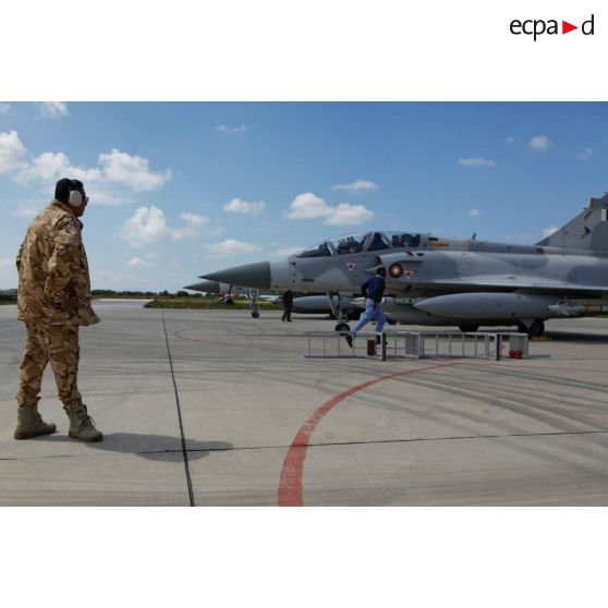 Pilotes qataris au cockpit de leur avion de combat Mirage 2000-5 QA 85 en phase d'allumage, prêts au départ en mission au signal du mécanicien de piste.