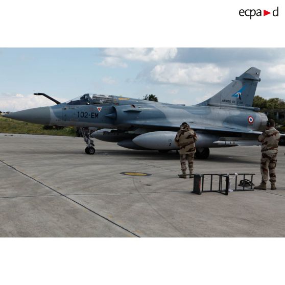 L'avion Mirage 2000-5 102-EM 63 de l'EC (escadron de chasse) 1/2 Cigognes au roulage pour un départ en mission en présence de personnels de piste.