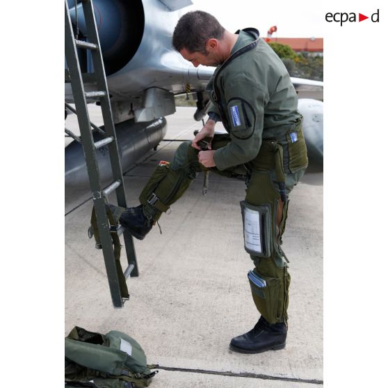 Au pied de l'échelle de son avion Mirage 2000-5 102-MK de l'EC (escadron de chasse) 1/2 Cigognes, un capitaine pilote ajuste sa combinaison de vol Aérazur.