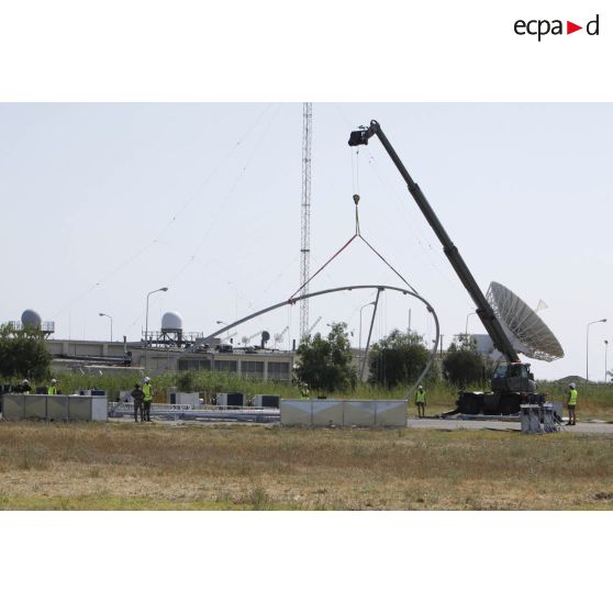 Aménagement d'une nouvelle zone pour accueillir un drone par les techniciens de l'armée de l'Air, sur la base aérienne de Sigonella. Levage d'un élément structurel de hangar par une grue Manitou.