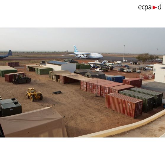 Derrière une zone de regroupement logistique, un avion-cargo de transport Antonov 124-100 ukrainien stationne sur une piste de l'aéroport de Bamako.