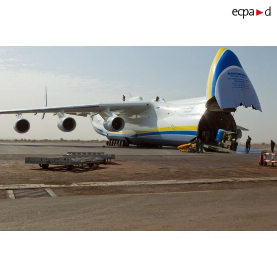 Déchargement de palettes de pneus de la soute d'un avion-cargo de transport Antonov 225 ukrainien par un engin manutention transpalette OM du RTP (régiment du train parachutiste).